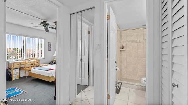 ensuite bathroom featuring tiled shower, toilet, ensuite bath, ceiling fan, and tile patterned flooring