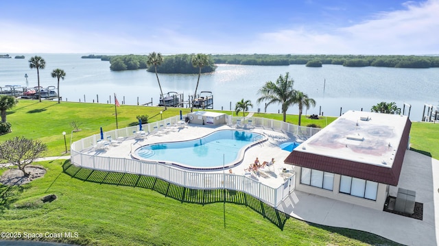 pool with a water view, a yard, fence, and a patio