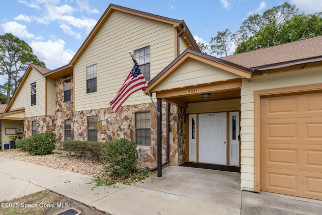 townhome / multi-family property featuring stone siding and roof with shingles