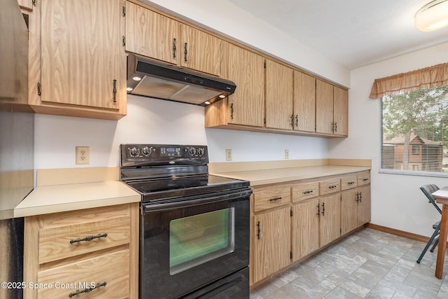 kitchen with black / electric stove, light countertops, stone finish flooring, under cabinet range hood, and baseboards