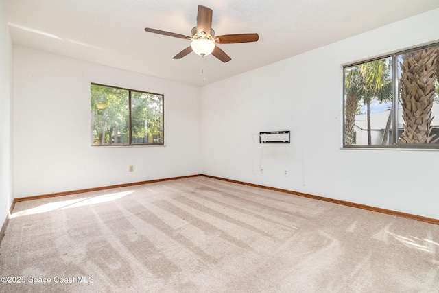 spare room with carpet floors, a wealth of natural light, and baseboards