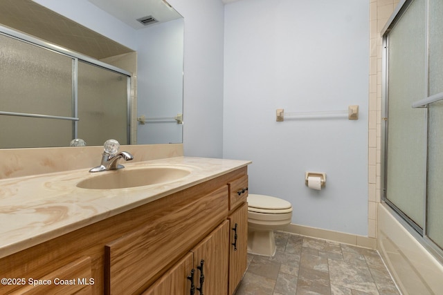 full bathroom with toilet, vanity, visible vents, baseboards, and stone finish floor