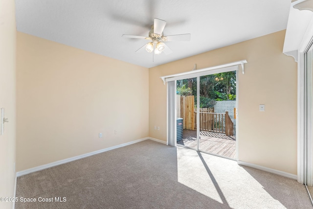 carpeted spare room featuring a ceiling fan and baseboards