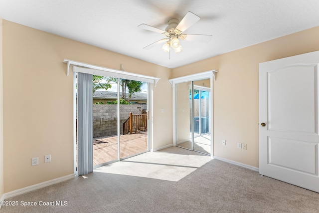 carpeted empty room featuring ceiling fan and baseboards