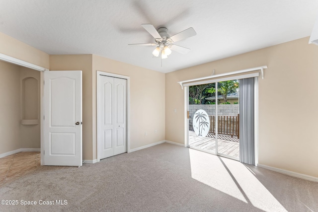 unfurnished bedroom featuring access to exterior, carpet, a closet, and a textured ceiling