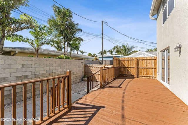 wooden terrace with a fenced backyard