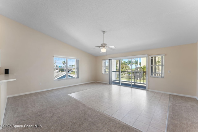 tiled spare room with lofted ceiling, plenty of natural light, a textured ceiling, and carpet