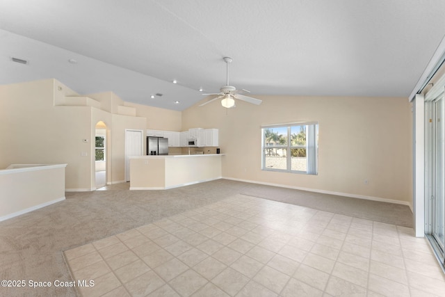 unfurnished living room with lofted ceiling, visible vents, light carpet, ceiling fan, and baseboards