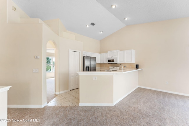 kitchen featuring visible vents, light colored carpet, white cabinetry, white appliances, and a peninsula