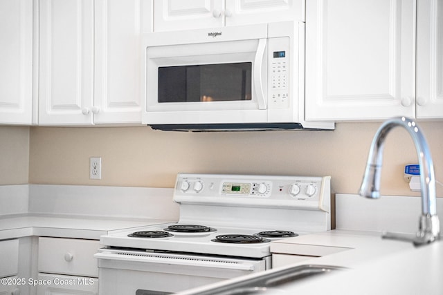 kitchen with light countertops, white appliances, and white cabinets