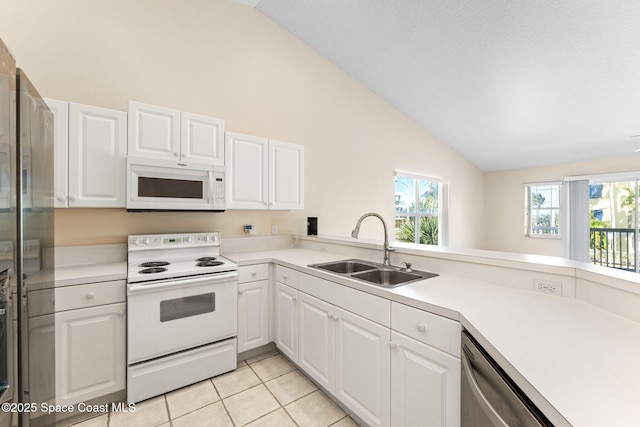 kitchen with white appliances, lofted ceiling, light countertops, white cabinetry, and a sink