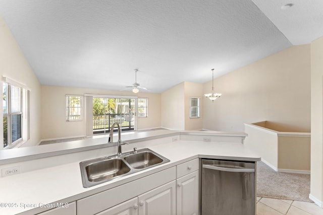 kitchen with lofted ceiling, light countertops, stainless steel dishwasher, and a sink