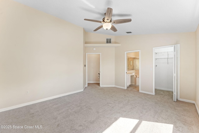 unfurnished bedroom featuring a spacious closet, visible vents, connected bathroom, and light colored carpet