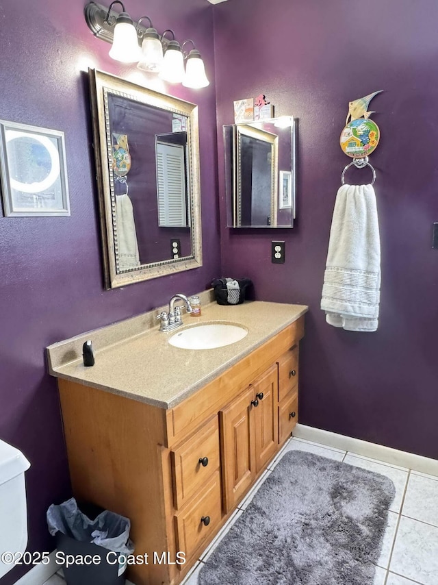 bathroom with vanity, baseboards, and tile patterned floors