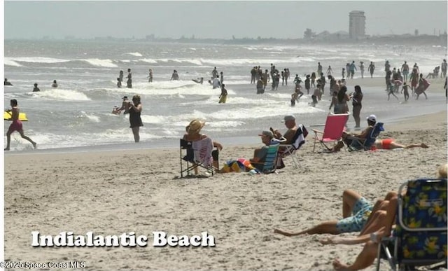 surrounding community with a water view and a view of the beach