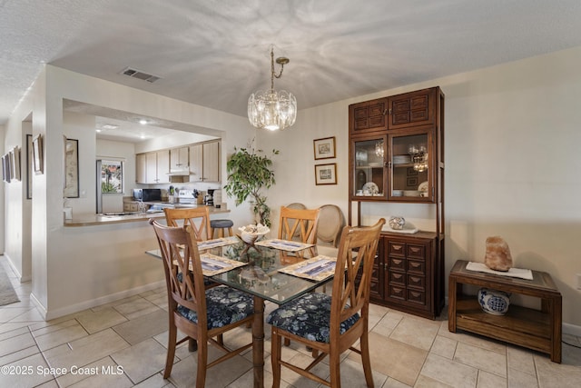 dining space featuring an inviting chandelier, baseboards, visible vents, and light tile patterned flooring