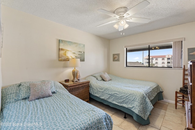 bedroom with light tile patterned floors, baseboards, a ceiling fan, and a textured ceiling