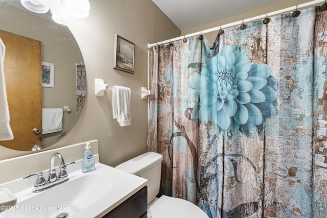 full bath with curtained shower, vanity, and toilet