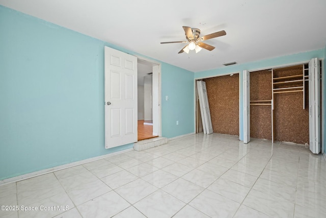 unfurnished bedroom with multiple closets, visible vents, ceiling fan, tile patterned flooring, and baseboards