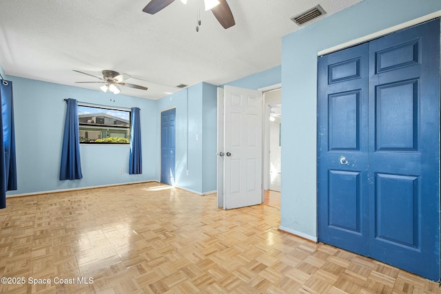 empty room featuring visible vents, ceiling fan, a textured ceiling, and baseboards