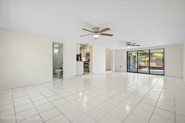 spare room with light tile patterned floors, ceiling fan, and baseboards