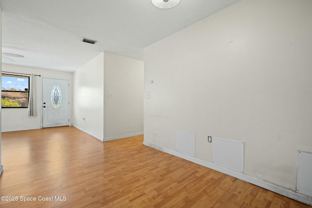 interior space with light wood-style floors, baseboards, and visible vents