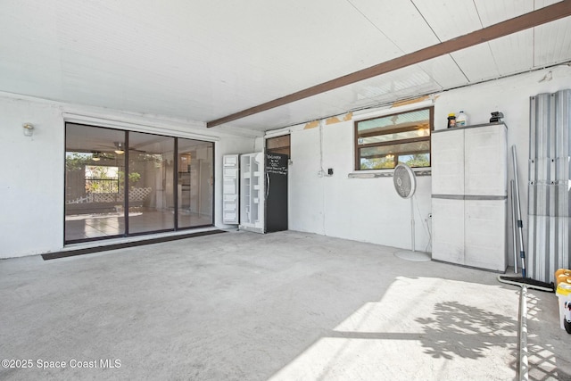 interior space featuring beamed ceiling and concrete floors