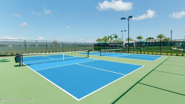 view of tennis court with community basketball court and fence