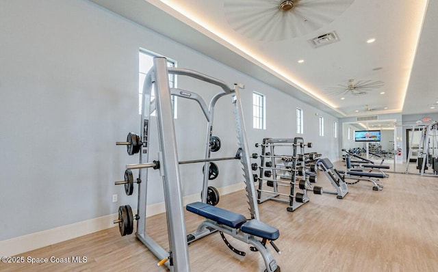 workout area featuring visible vents, a raised ceiling, wood finished floors, recessed lighting, and baseboards