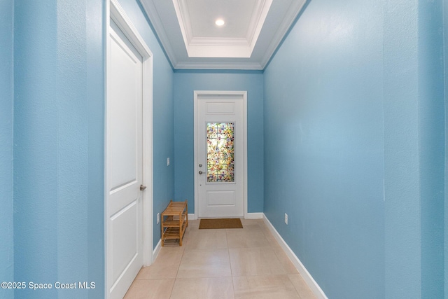 doorway to outside with crown molding, light tile patterned floors, baseboards, and a tray ceiling