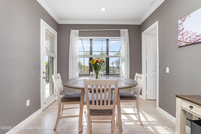 dining area with light tile patterned floors, crown molding, and baseboards