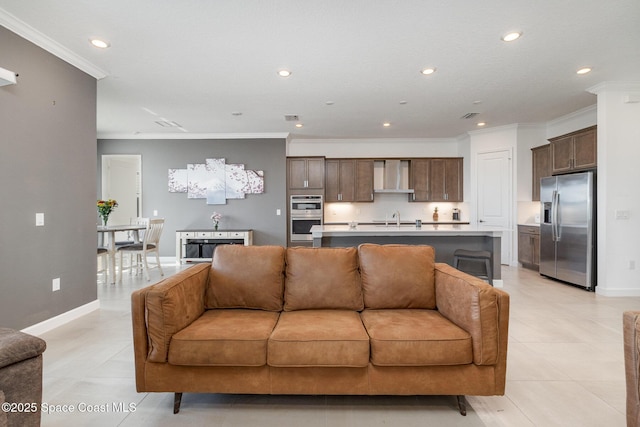 living room with crown molding, recessed lighting, baseboards, and visible vents