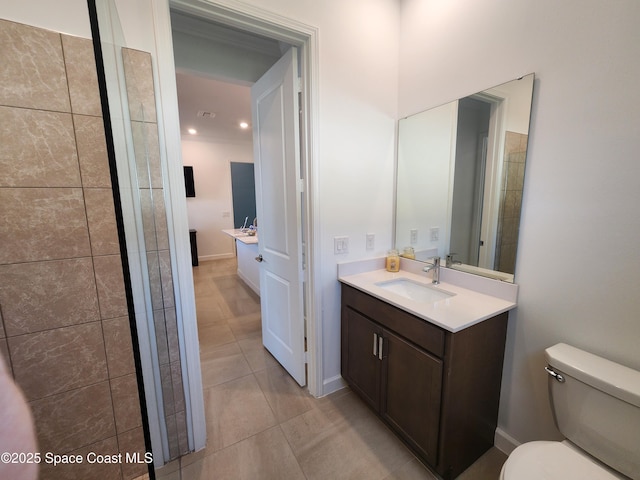 bathroom with tile patterned flooring, toilet, vanity, and baseboards