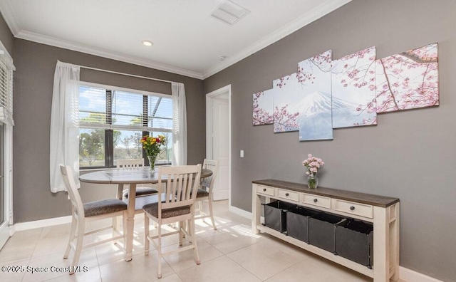 dining space with light tile patterned flooring, visible vents, crown molding, and baseboards