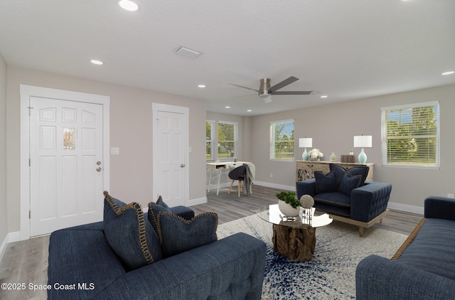 living room featuring recessed lighting, wood finished floors, visible vents, and baseboards