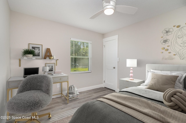 bedroom with a ceiling fan, baseboards, and wood finished floors