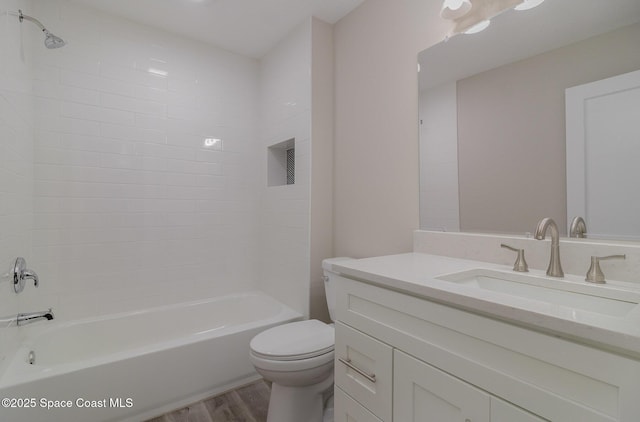 bathroom with toilet, tub / shower combination, wood finished floors, and vanity