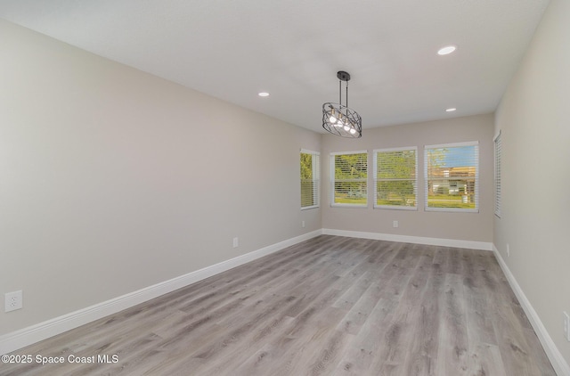 empty room featuring recessed lighting, light wood-type flooring, and baseboards