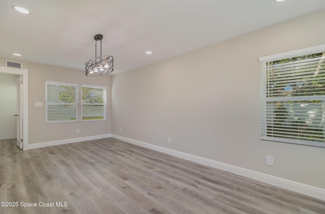 spare room with light wood-type flooring, visible vents, baseboards, and recessed lighting