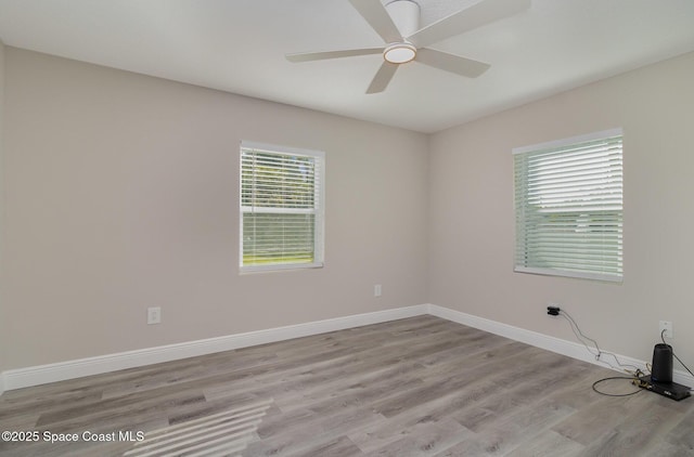 spare room with light wood-style flooring, baseboards, and a ceiling fan