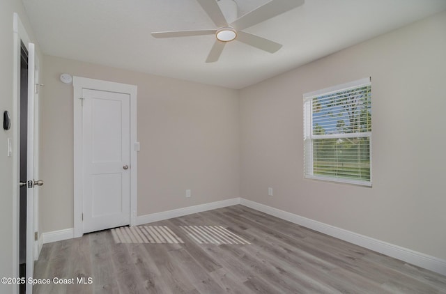 unfurnished room featuring ceiling fan, baseboards, and wood finished floors