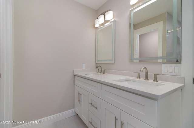 bathroom with a sink, baseboards, and double vanity