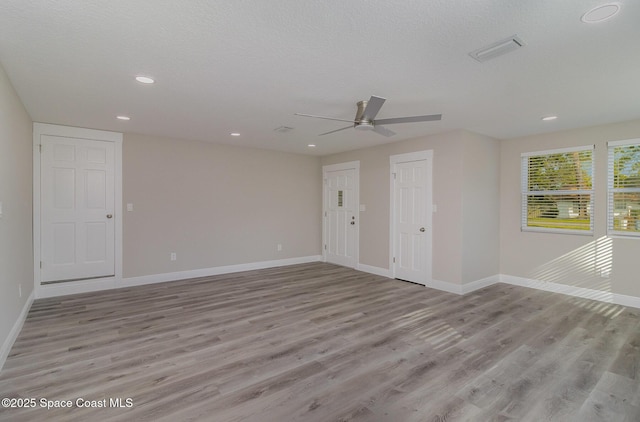 empty room with baseboards, visible vents, and light wood-style floors