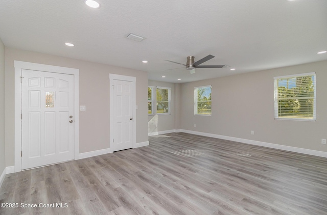 empty room with light wood-style flooring, recessed lighting, visible vents, a ceiling fan, and baseboards