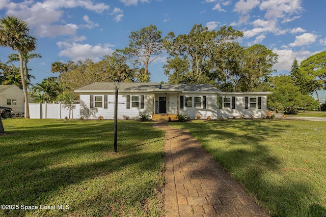 ranch-style home with a front yard and fence