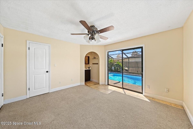 interior space featuring baseboards, light carpet, a sunroom, a textured ceiling, and access to outside