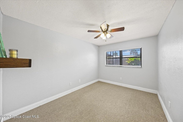 carpeted empty room with baseboards, a textured ceiling, and a ceiling fan