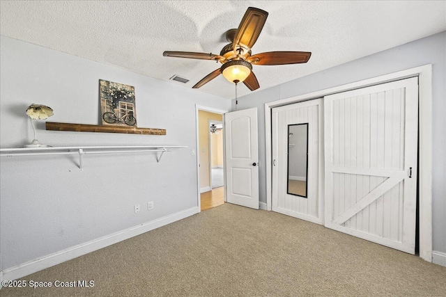 unfurnished bedroom featuring visible vents, baseboards, carpet, a closet, and a textured ceiling