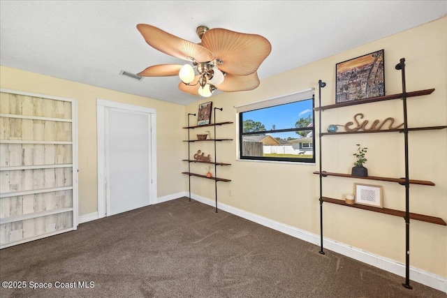 interior space featuring visible vents, baseboards, carpet, and a ceiling fan