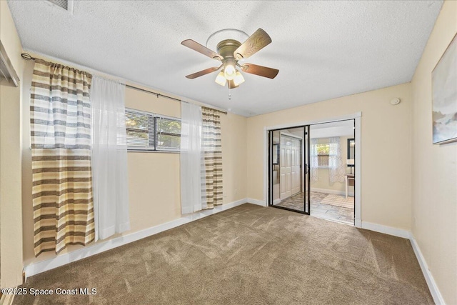 spare room featuring baseboards, carpet, and a textured ceiling